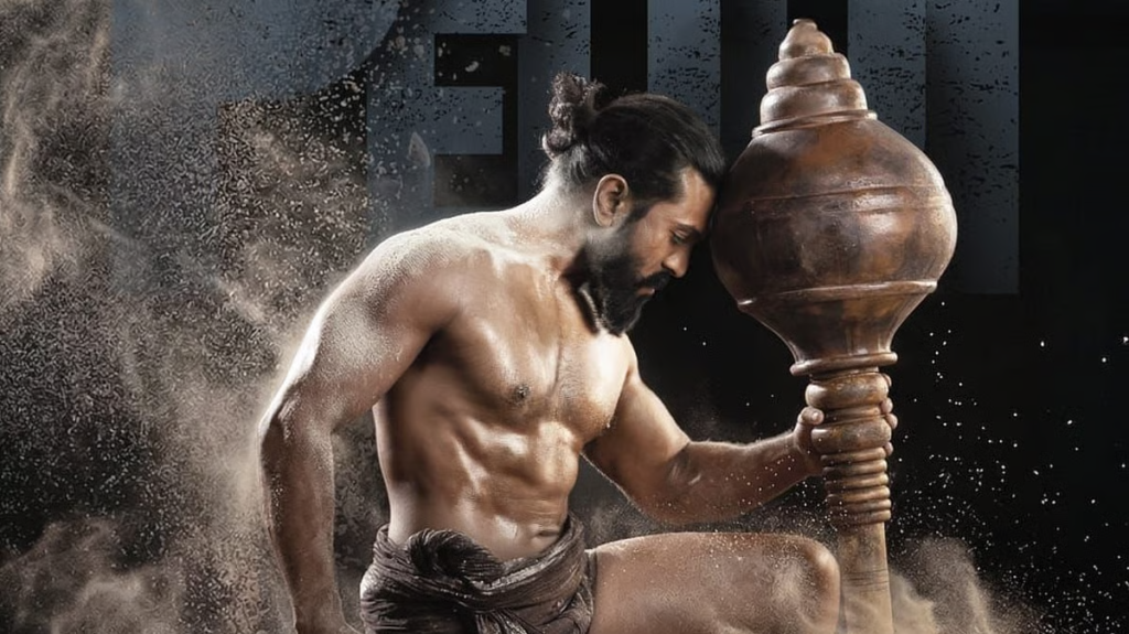 A shirtless, bearded man grips a large wooden club as dust swirls around him.