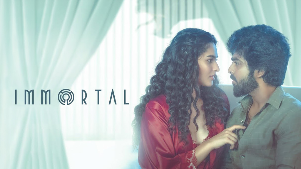 Immortal film title beside a woman in red facing a man in a green shirt.