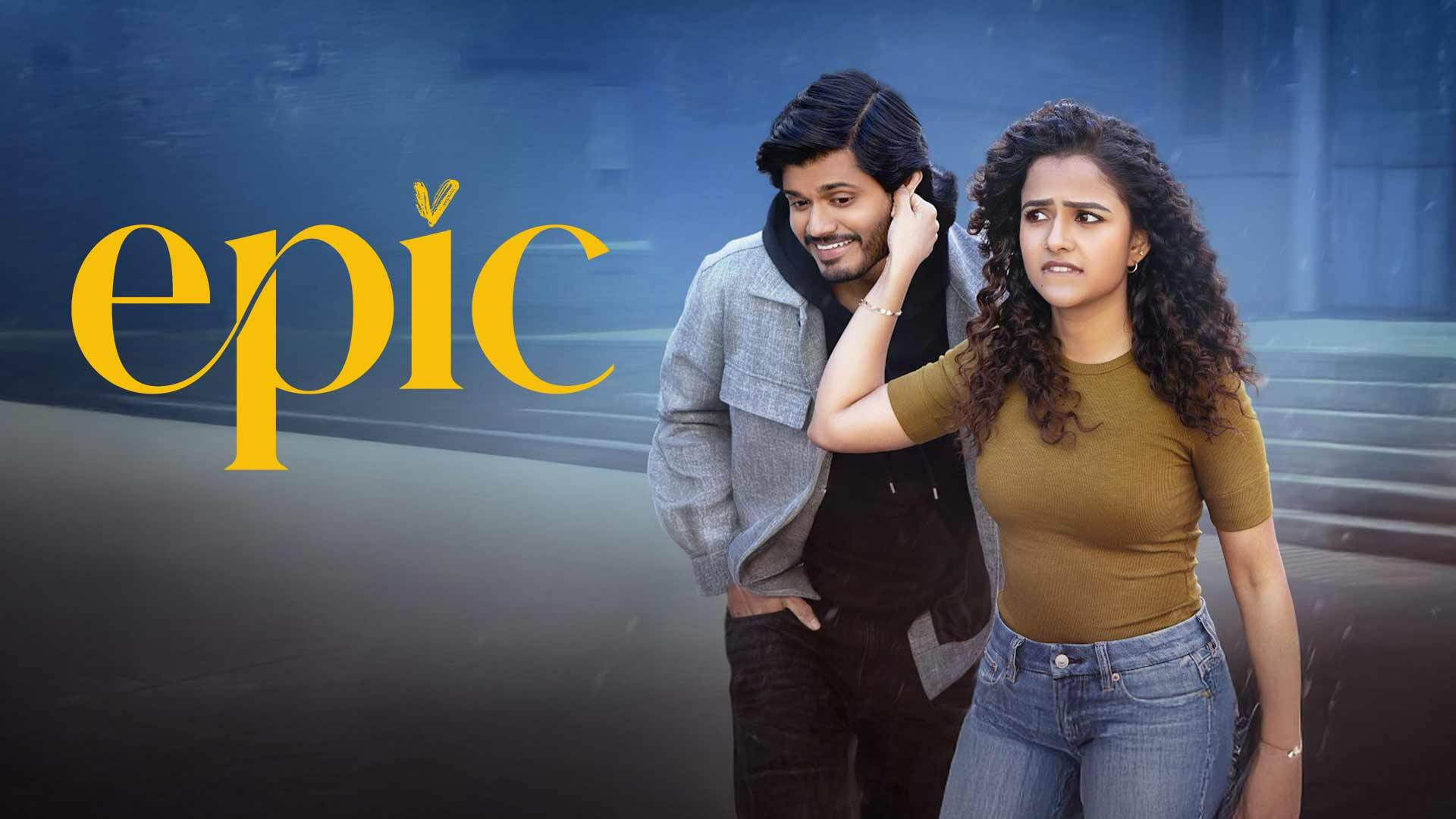 Epic title graphic beside a man and woman standing together, with the woman touching the man's ear.